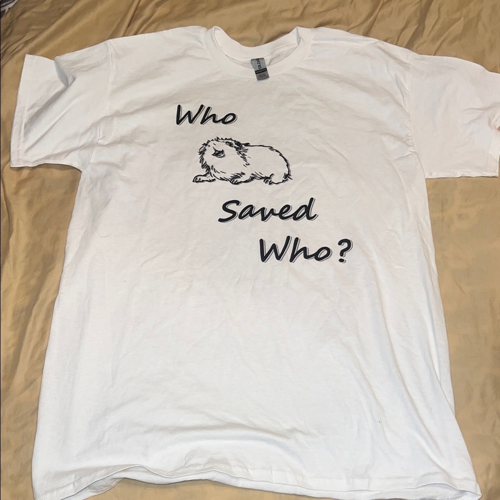 White short sleeve shirt with Who Saved Who?" and a drawing of a guinea pig. 
L